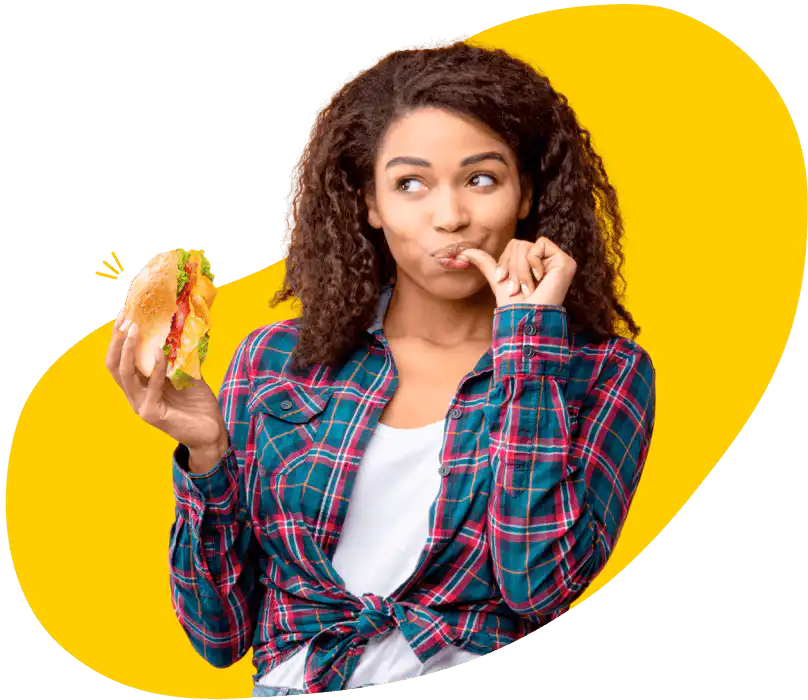 Mujer comiendo un sándwich con Nestlé® ¡Qué Rico!